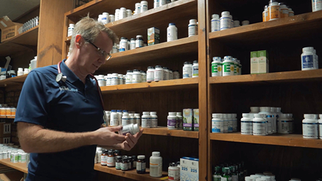 Doctor looking at a supplements bottle in the inventory